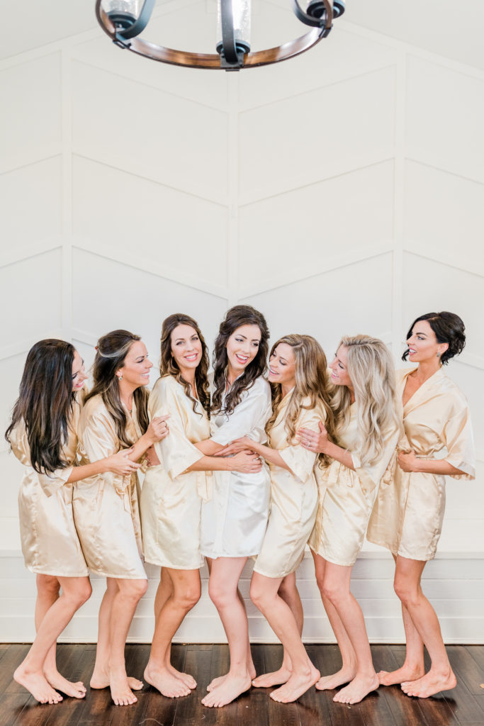 Blush Rose Gold Wedding Bride and Bridesmaids Getting Ready Robes Laughing | Sunset Oaks in Tyler TX by DFW Dallas Fort Worth wedding photographer Karina Danielle Photography