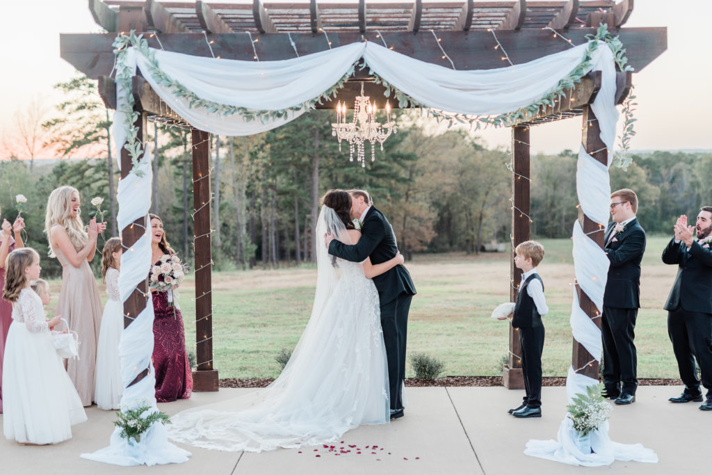 Wedding Ceremony Bride and Groom Kissing Fall Blush Rose Gold Pink Wine Wedding | Sunset Oaks in Tyler TX by DFW Dallas Fort Worth wedding photographer Karina Danielle Photography
