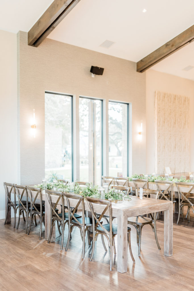 Reception Hall Farmhouse Tables Greenery Candles Table Numbers | Stonehouse Villa in Driftwood TX by DFW Dallas Fort Worth wedding photographer Karina Danielle Photography