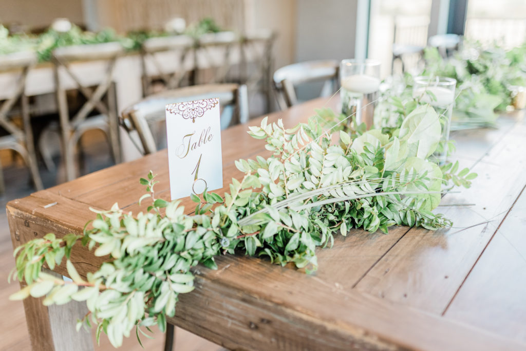 Reception Hall Farmhouse Tables Greenery Candles Table Numbers | Stonehouse Villa in Driftwood TX by DFW Dallas Fort Worth wedding photographer Karina Danielle Photography