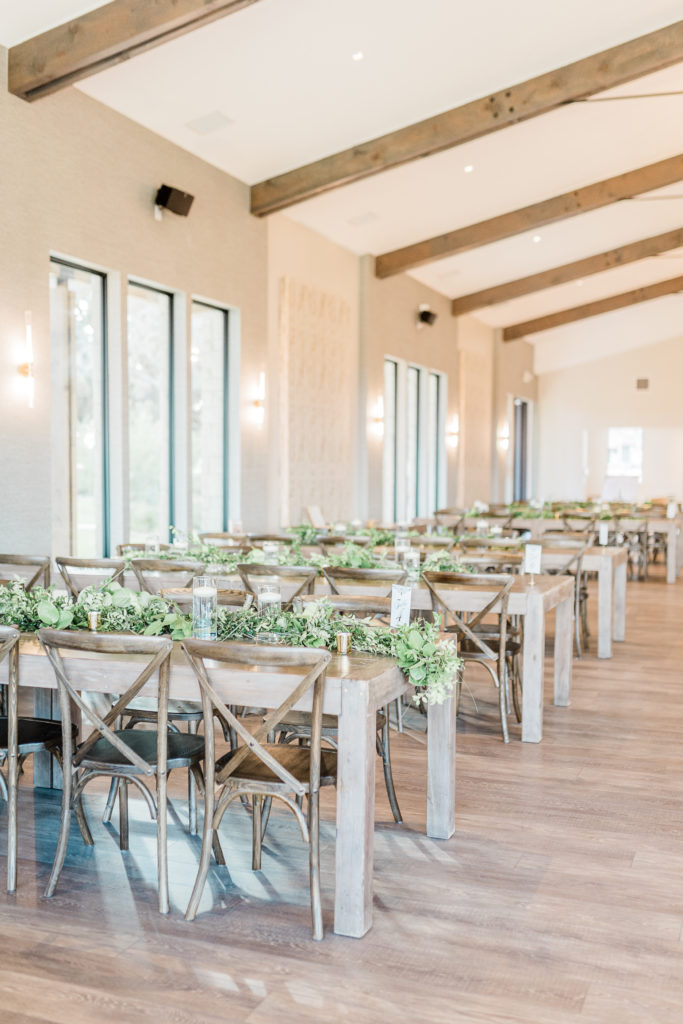Reception Hall Farmhouse Tables Greenery Candles Table Numbers | Stonehouse Villa in Driftwood TX by DFW Dallas Fort Worth wedding photographer Karina Danielle Photographyv