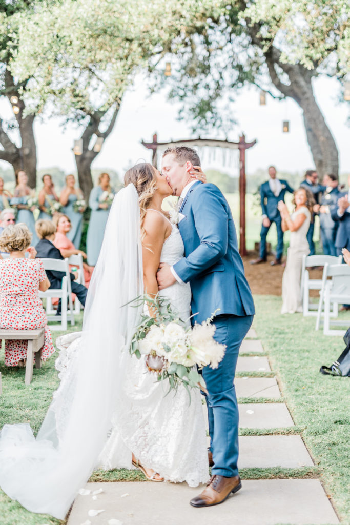 Bride and Groom Ceremony Recessional Lace Dress Navy Suit Bouquet | Stonehouse Villa in Driftwood TX by DFW Dallas Fort Worth wedding photographer Karina Danielle Photography