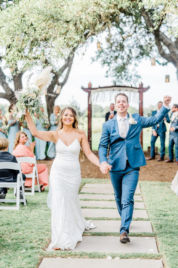 Bride and Groom Ceremony Recessional Lace Dress Navy Suit Bouquet | Stonehouse Villa in Driftwood TX by DFW Dallas Fort Worth wedding photographer Karina Danielle Photography