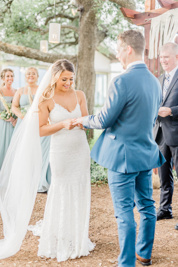 Bride and Groom Ceremony Ring Exchange Lace Dress Navy Suit | Stonehouse Villa in Driftwood TX by DFW Dallas Fort Worth wedding photographer Karina Danielle Photography