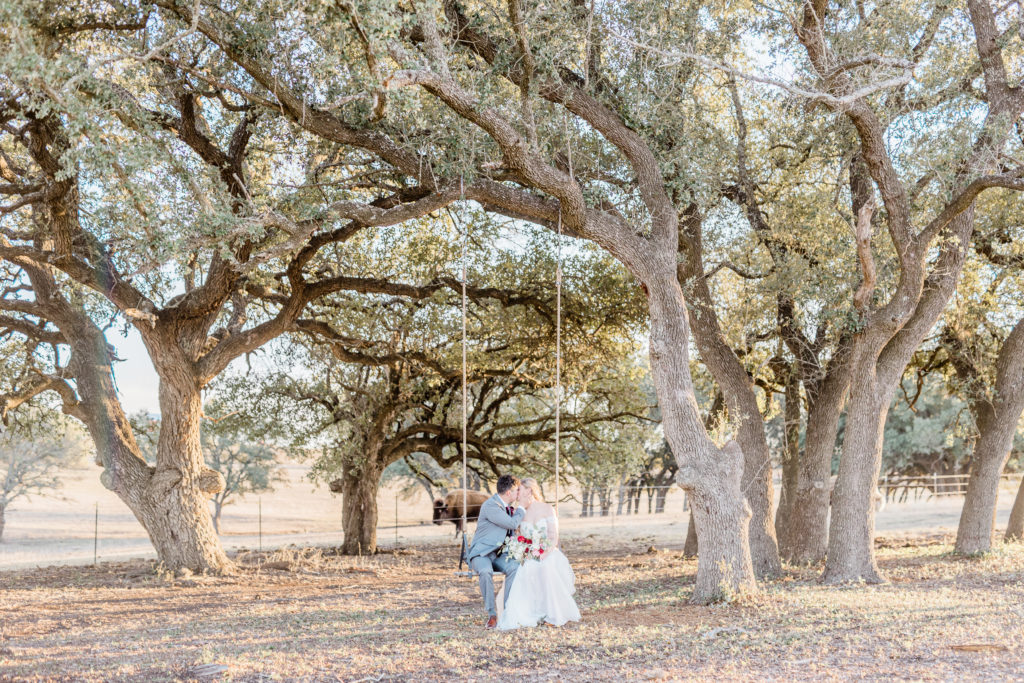 Bride and Groom Sunset Portrait Strapless Dress Grey Suit Velvet Tie Blush and Wine Bouquet Eucalyptus | Wagon Springs Ranch in Burnet TX by DFW Dallas Fort Worth wedding photographer Karina Danielle Photography