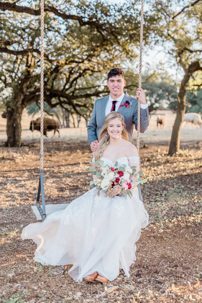 Bride and Groom Sunset Portrait Strapless Dress Grey Suit Velvet Tie Blush and Wine Bouquet Eucalyptus | Wagon Springs Ranch in Burnet TX by DFW Dallas Fort Worth wedding photographer Karina Danielle Photography