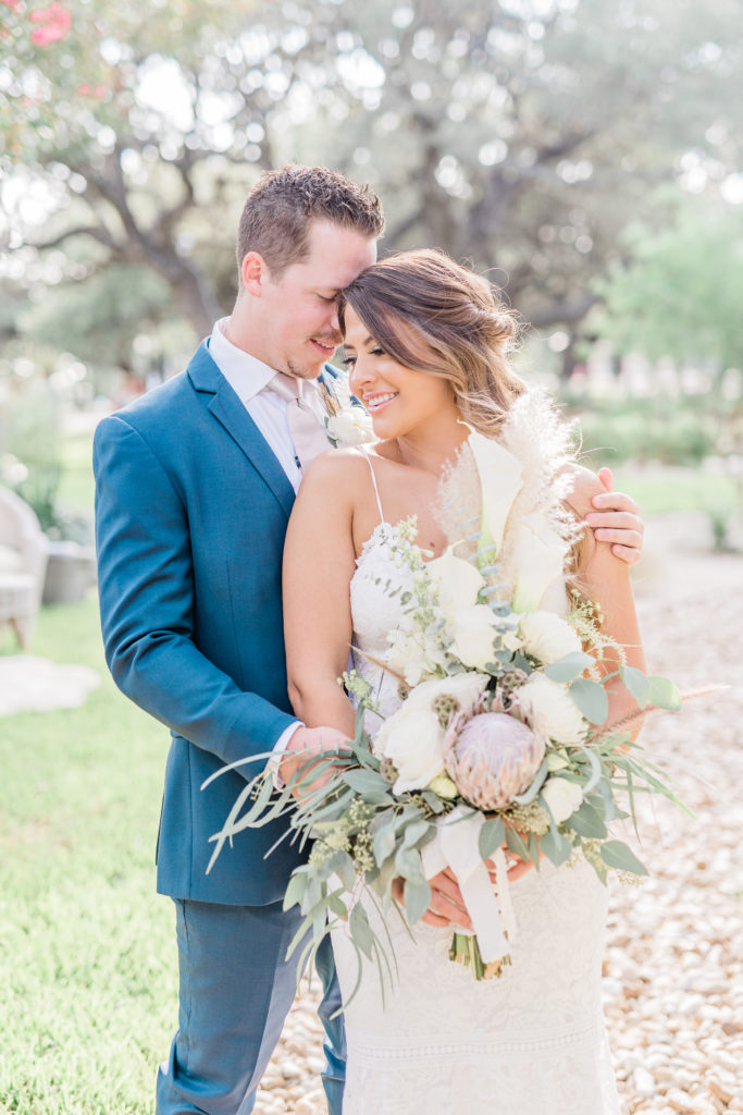 Bride and Groom Portraits Lace Dress Navy Suit Pampas Grass Bouquet Boho | Stonehouse Villa in Driftwood TX by DFW Dallas Fort Worth wedding photographer Karina Danielle Photography