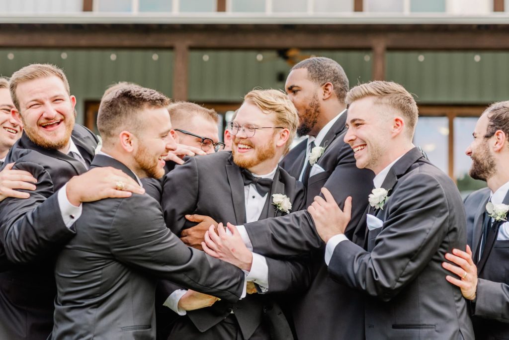 Groomsmen Embracing Groom in Group Hug | Carleen Bright Arboretum in Waco TX by DFW Dallas wedding photographer Karina Danielle Photography