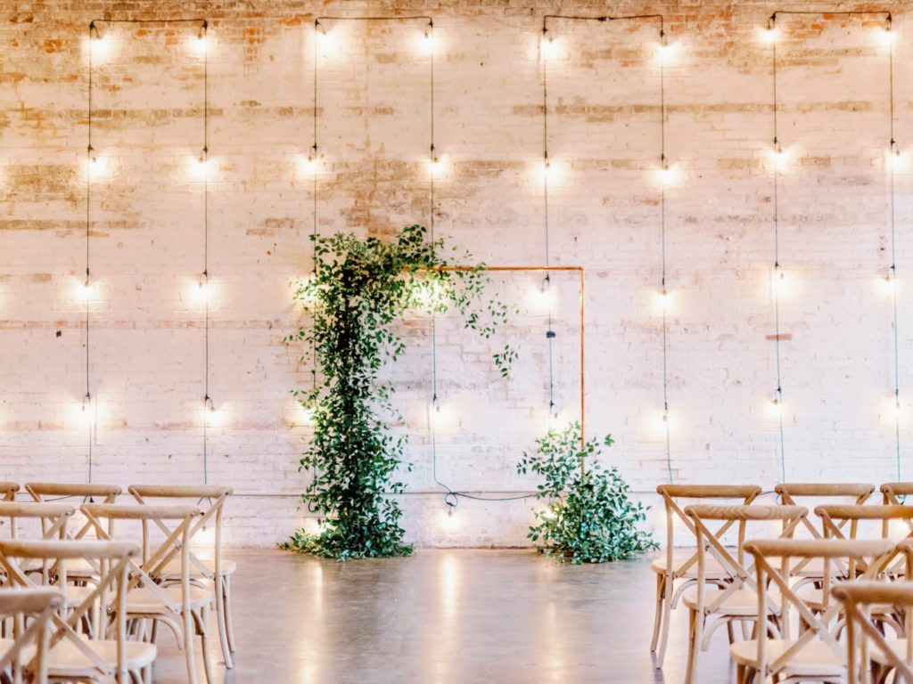 Empty wedding ceremony arch with greenery at Dallas Wedding Venue Brake and Clutch Warehouse.