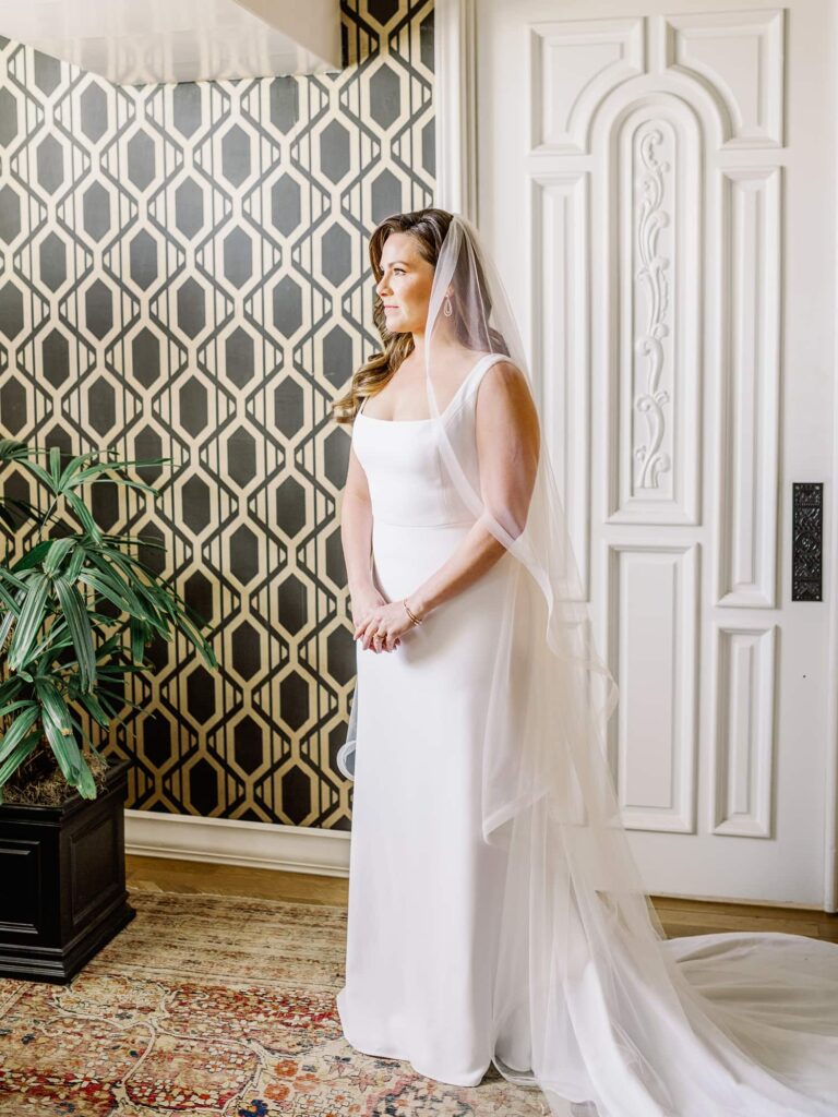 Bride with modern satin dress and tulle veil at bridal suite at The Mason Dallas.