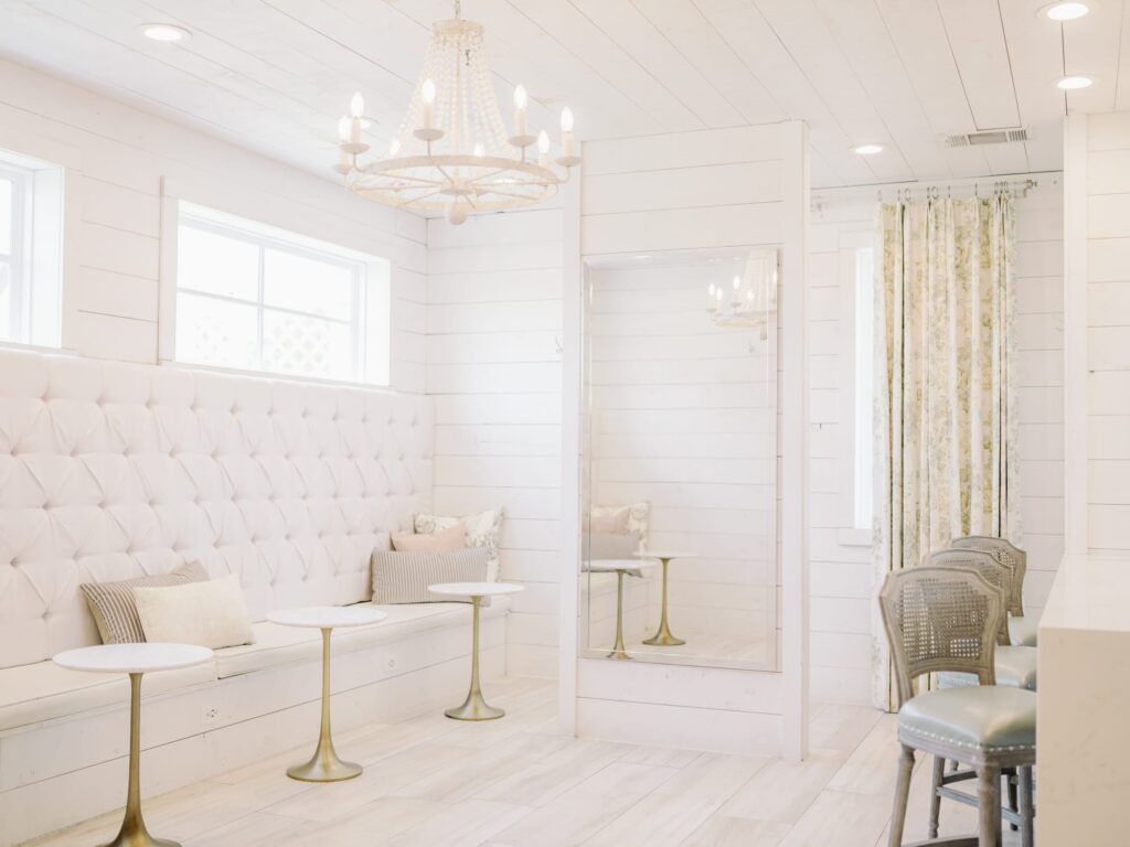 The Nest at Ruth Farms bridal suite with white walls, chandelier and full-length mirror.