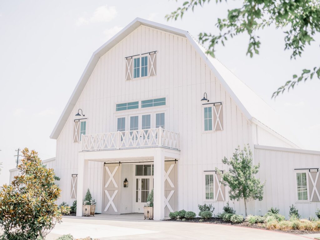 Exterior of a white barn at the Nest at Ruth farms with windows and shutters.