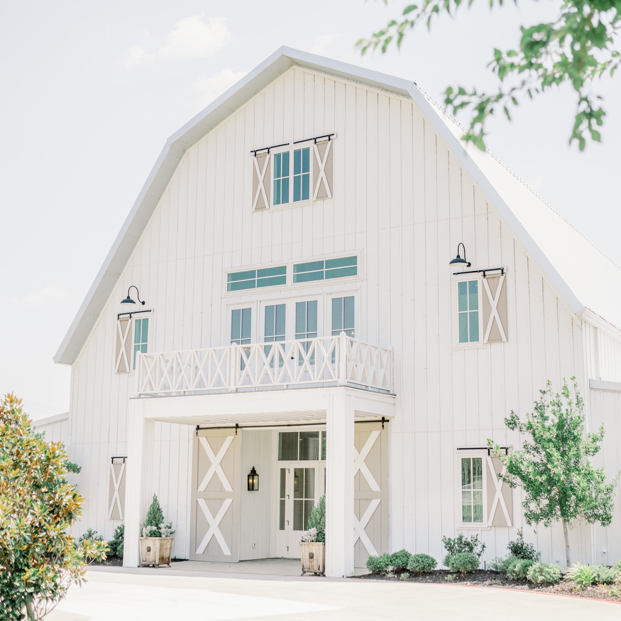 Exterior of the white barn at the Nest at Ruth Farms with windows and shutters.