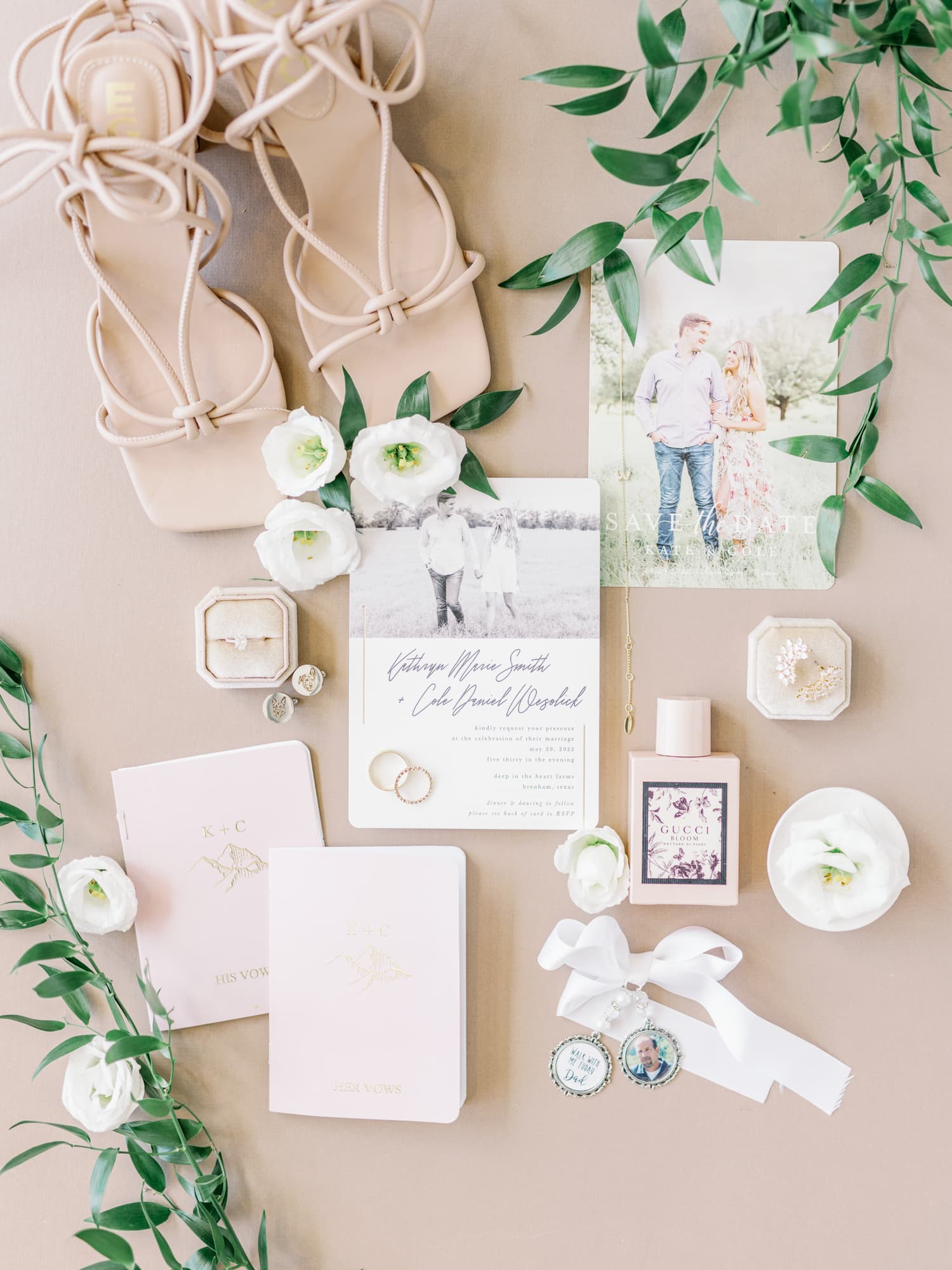 Wedding detail suite with invitation, save the date, earrings, florals and vow books.